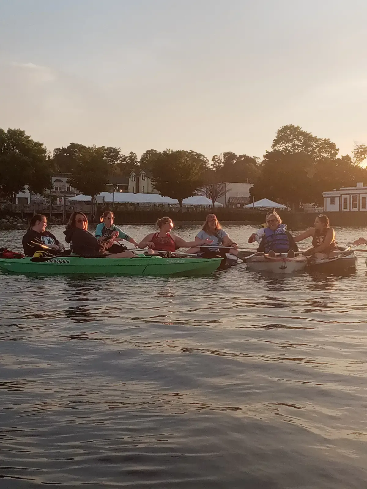 Kayakers and canoeists paddling together at sunset on the Straits of Mackinac
