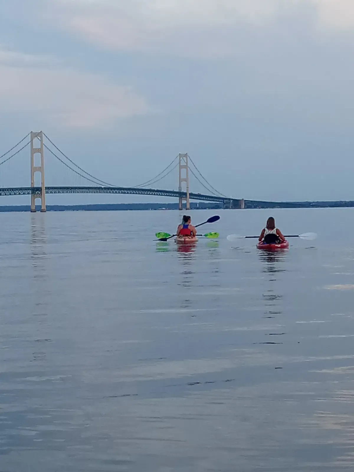 Two kayakers paddling toward the Mackinac Bridge on a bridge viewing tour